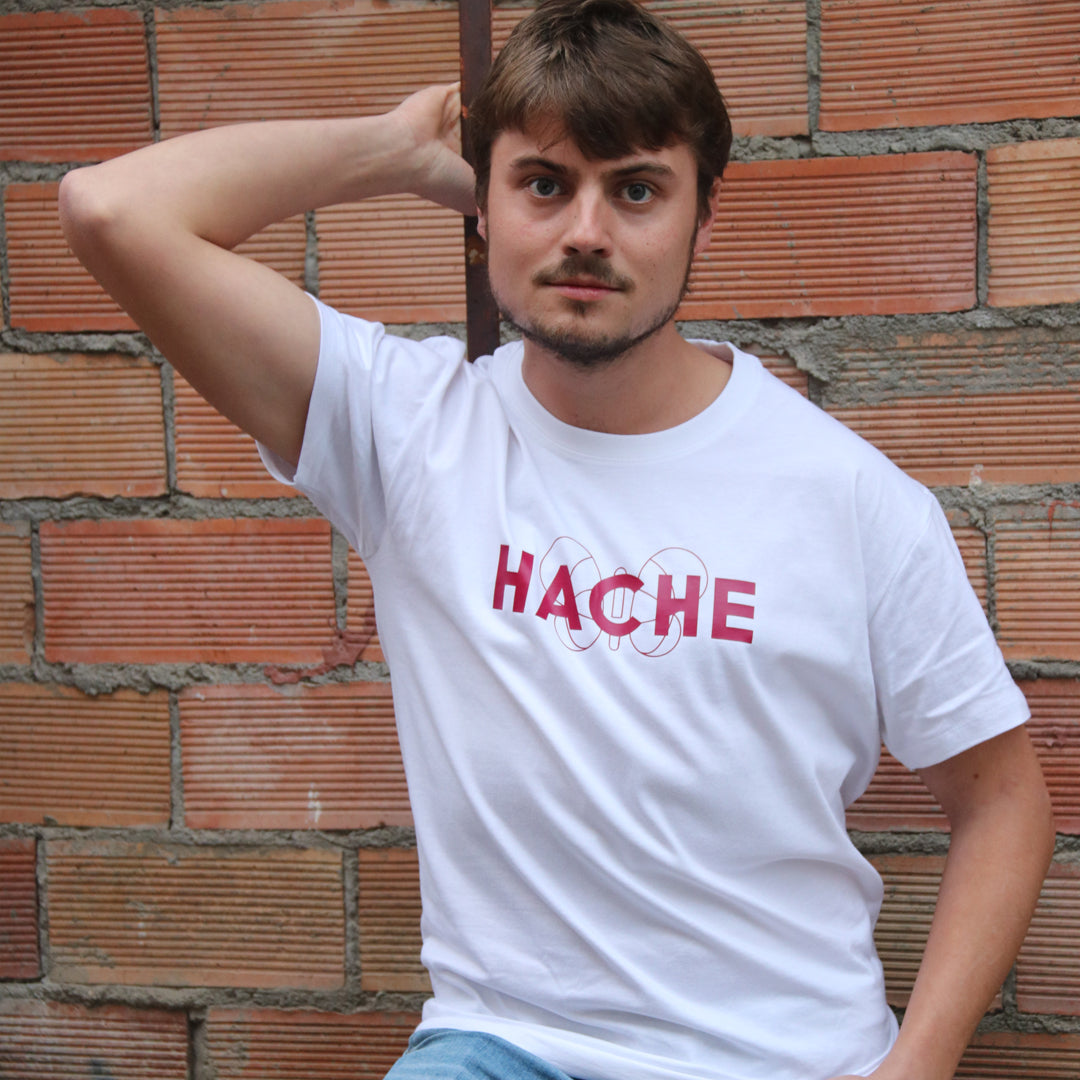 chico con camiseta blanca de manga corta con silueta de mariposa color burdeos central y palabra HACHE superpuesta a la mariposa