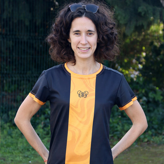 camiseta deportiva unisex negra con línea central naranja y silueta mariposa negra en el centro