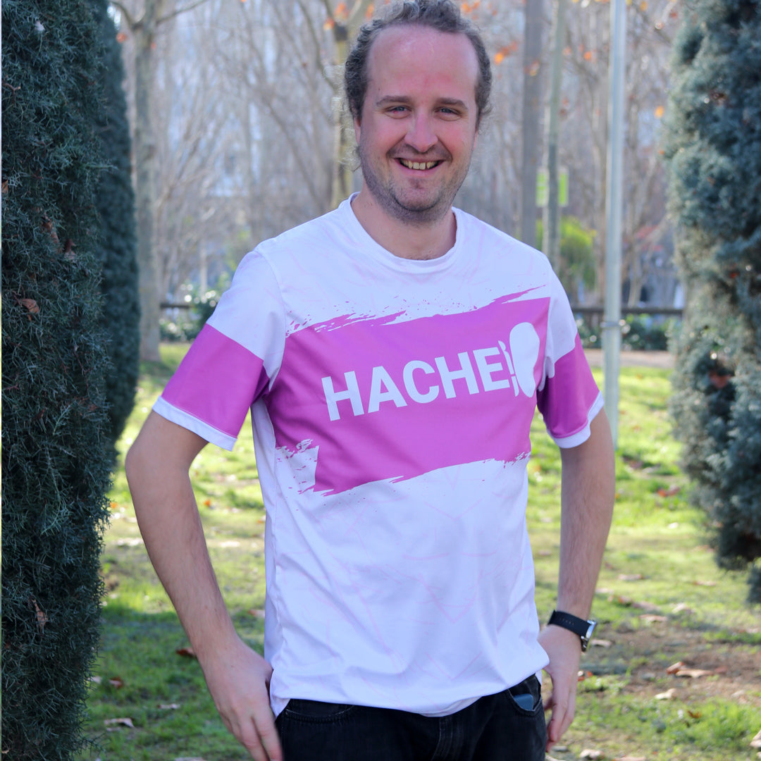 camiseta deportiva unisex blanca con franja central horizontal rosa y palabra HACHE en blanco sobre la franja
