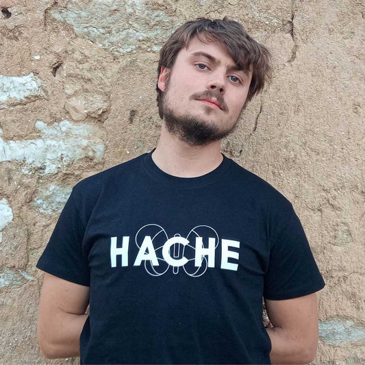 chico con camiseta negra de manga corta con silueta de mariposa blanca central y palabra HACHE superpuesta a la mariposa