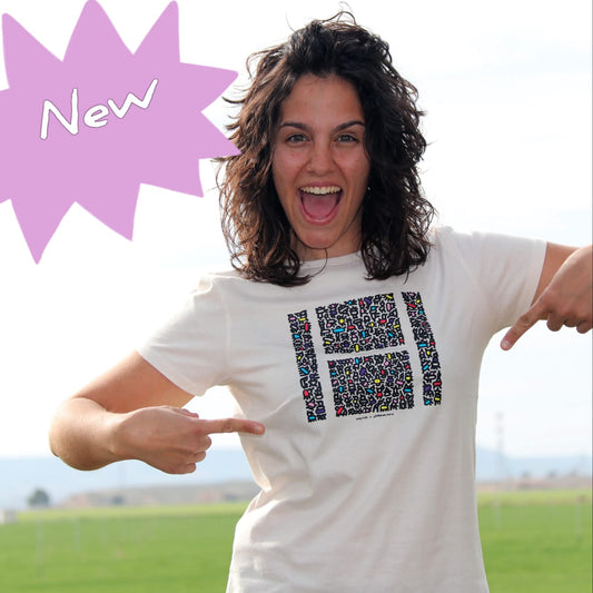 Chica en primer plano se señala con las dos manos el dibujo de la camiseta: un cuadrado estampado con una H escrita en blanco