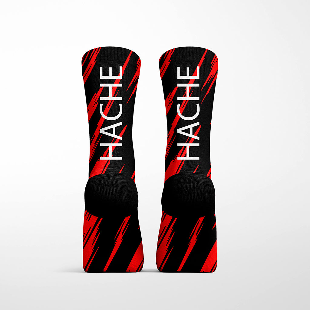 calcetín técnico negro con líneas rojas y palabra HACHE blanca trasera
